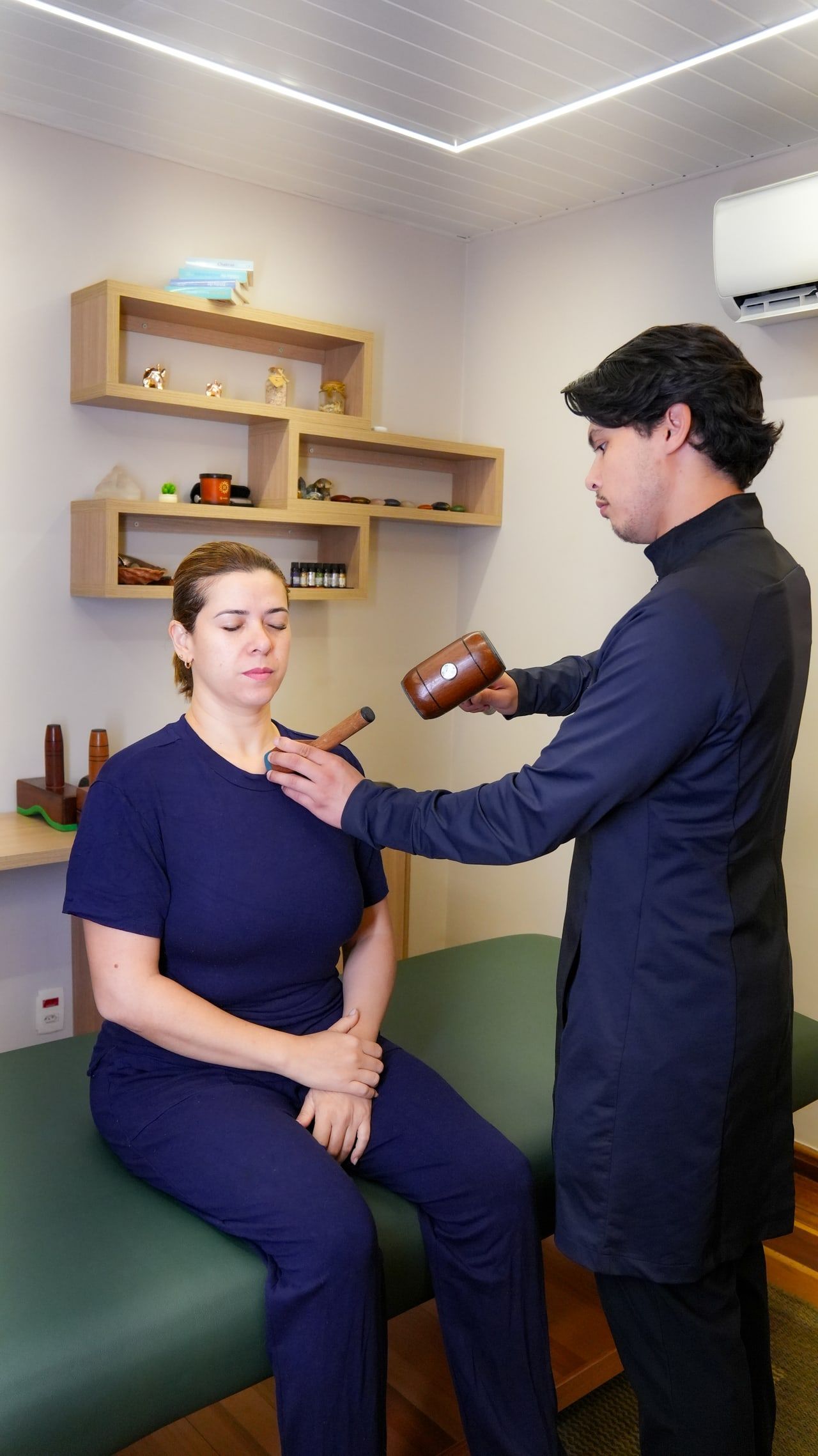 Higor Couto atendendo uma paciente sentada na maca do consultório