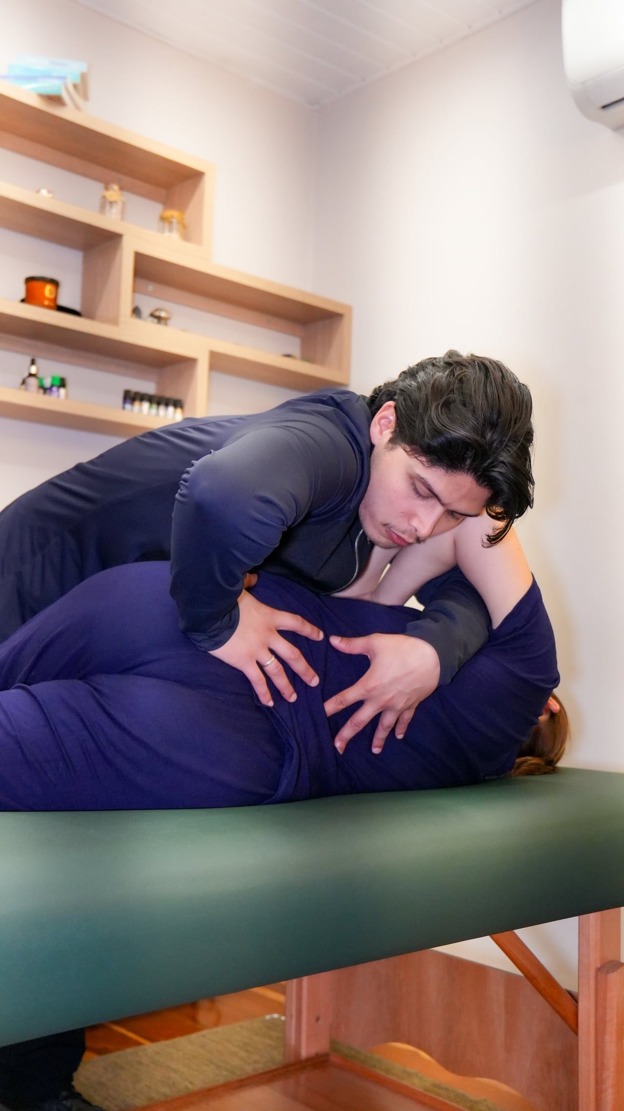 Higor Couto fazendo um ajuste na lombar de uma paciente deitada de lado