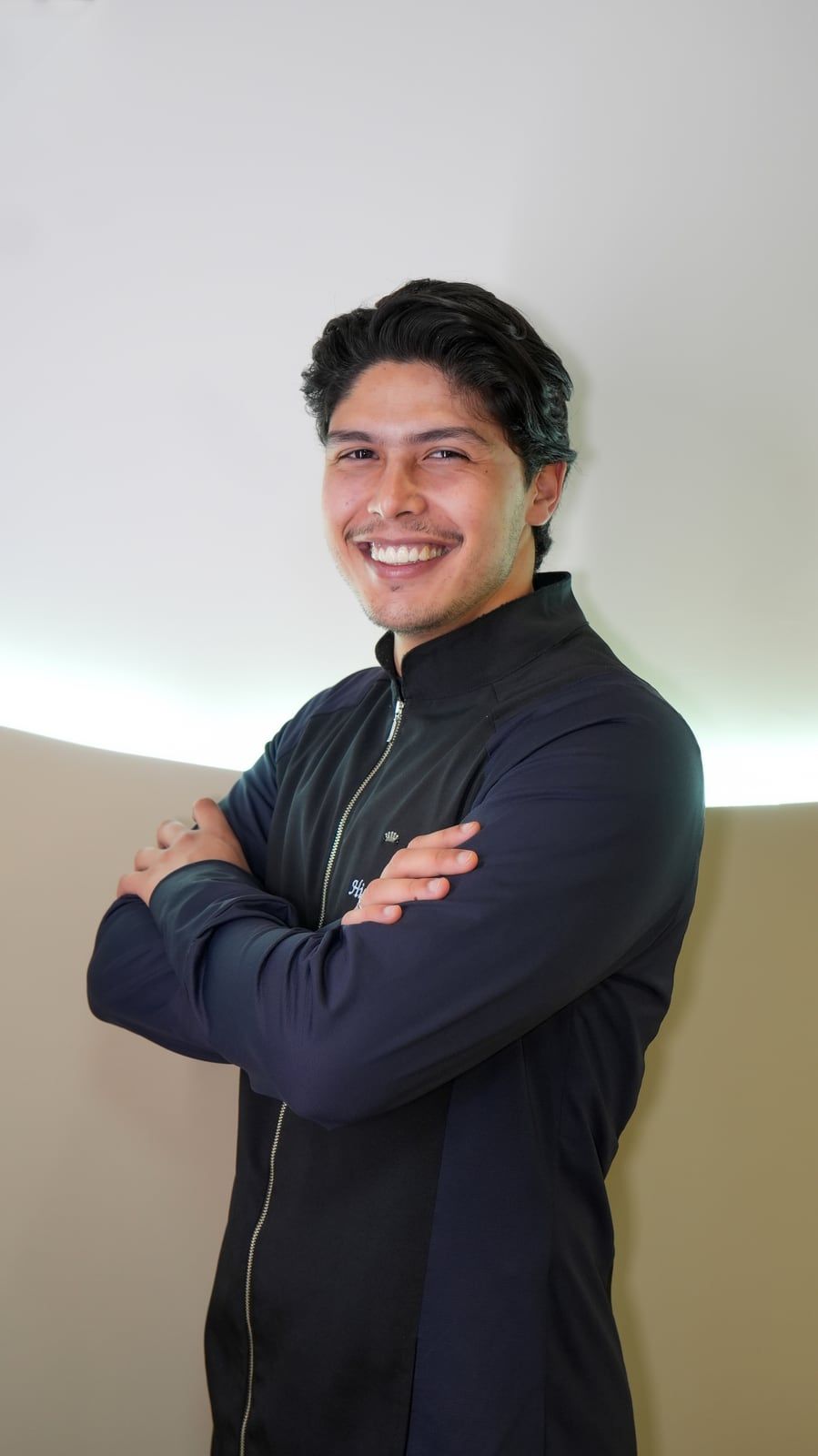 Higor Couto sorrindo, de braços cruzados